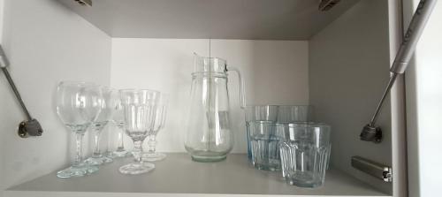 a row of empty glasses sitting on a shelf at Apartamenty K netflix wi-fi gratis in Wałbrzych