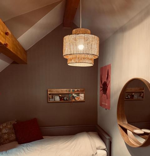 a bedroom with a bed and a chandelier at Five Trees Forest Home in Lanaken