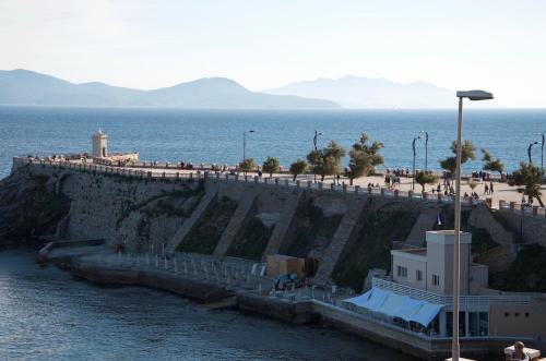 a group of people walking on a pier near the water at On the Tuscan coast in Piombino