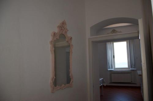 a mirror hanging on a wall next to a window at On the Tuscan coast in Piombino