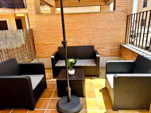 a patio with two chairs and a table with a lamp at AP Rooms in Almorox