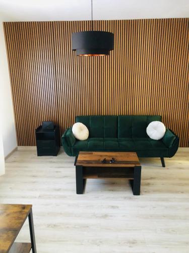a living room with a green couch and a coffee table at Casa Eraclea Venice in Eraclea