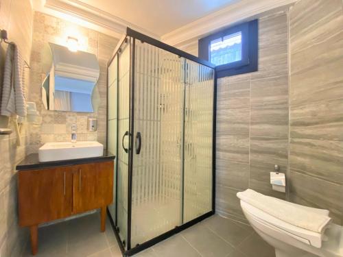 a bathroom with a shower and a toilet and a sink at B&B Boutique Hotel in Dalyan