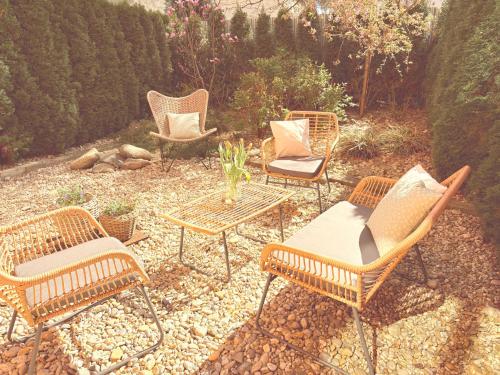 four rattan chairs and a table and chairs on a patio at Trio Apartments in Ostrava