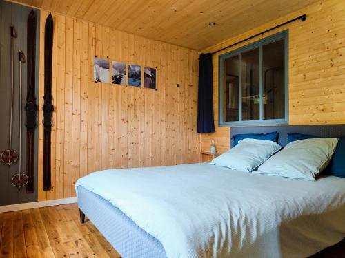 une chambre avec un grand lit avec une fenêtre dans l'établissement Le Cottage, à Messeix
