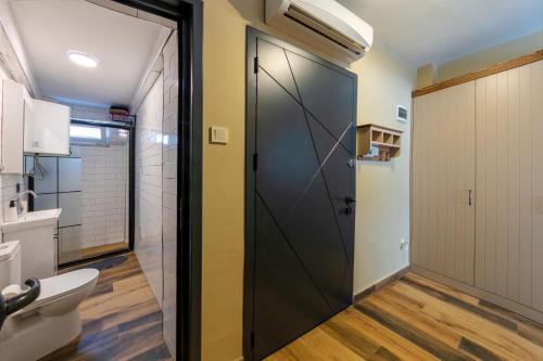a bathroom with a black door and a toilet at Kadıköy Modern Loft & Equipped Stay in Istanbul