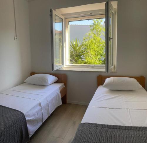 two beds in a room with a window at Suzy apartment, Dugi Rat in Dugi Rat
