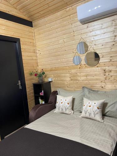 a bedroom with a bed and a wooden wall at Cozy Lake House in Cinciş