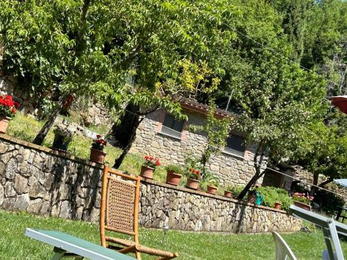 a wooden chair sitting in front of a stone wall at Casetta Girasole - Monterchi in Monterchi