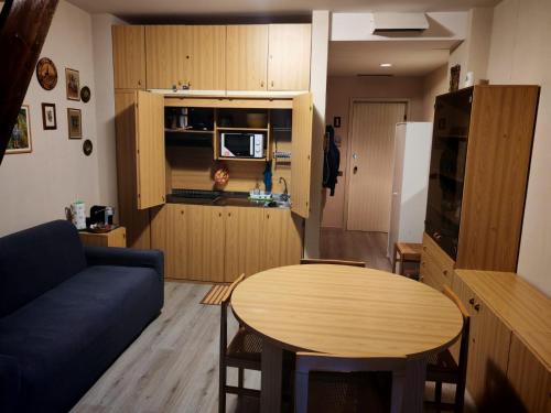 a living room with a blue couch and a table at Presolana House in Castione della Presolana