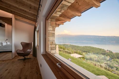 a room with a large window looking out at the water at Colago Private Villas Lake Garda in Toscolano Maderno