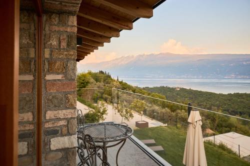 a balcony with a table and an umbrella at Colago Private Villas Lake Garda in Toscolano Maderno