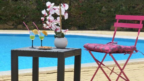 une table avec une chaise, un vase de fleurs et deux verres dans l'établissement VIEW port venus naturiste, au Cap d'Agde
