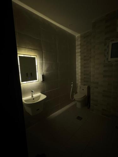 a dark bathroom with a sink and a toilet at استديو 1 in Jeddah