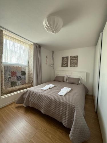a bedroom with a bed with two towels on it at Casa do Albano in Viana do Castelo