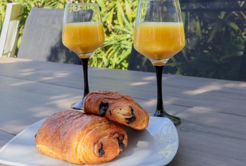 deux verres de jus d'orange et deux pâtisseries sur une table dans l'établissement Marineo by POM, pkg, terrasse, au Cap d'Agde