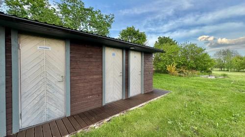 a building with two garage doors on a grass field at Pühajõe Holiday Park in Pühajõe