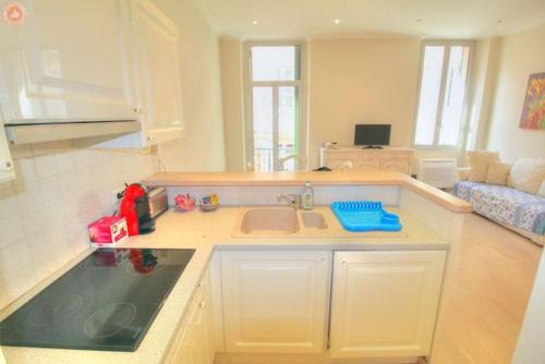 une cuisine avec un évier et un salon dans l'établissement ALC - FONT3 - 10 min PALAIS, à Cannes