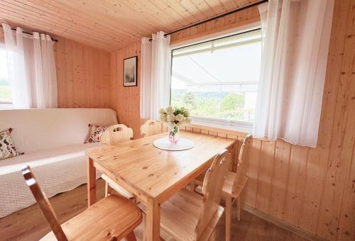 a dining room with a wooden table and a window at Domki letniskowe Ferencówka Bieszczady 506-747-773 in Zawóz