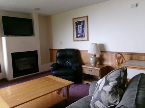 a living room with a couch and a chair and a fireplace at Seahorse Oceanfront Lodge in Lincoln City