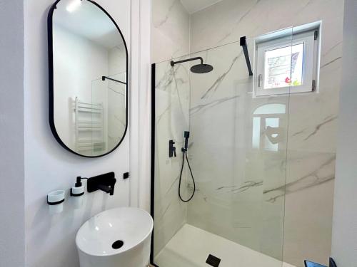 a bathroom with a shower and a sink and a mirror at Romantic central apartment in Constanţa