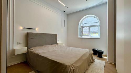 a bedroom with a bed and an arch window at Romantic central apartment in Constanţa