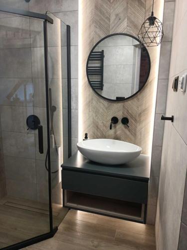 a bathroom with a sink and a mirror at Domek Sasino in Sasino