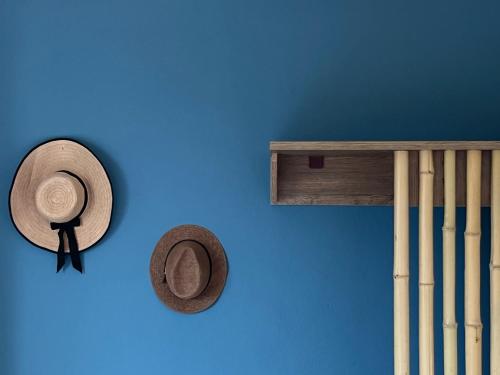 two hats on a blue wall next to some baseball bats at Makedos Sea View in Nea Vrasna