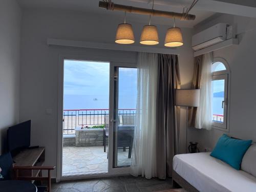 a bedroom with a bed and a sliding glass door at Makedos Sea View in Nea Vrasna