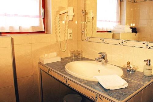 a bathroom with a sink and a mirror at Hotel Edelweiẞ garni - b&b in Berwang
