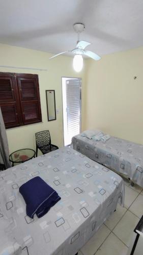 a bedroom with two beds and a ceiling fan at Suites Solar dos Arcanjos Guaramiranga in Guaramiranga
