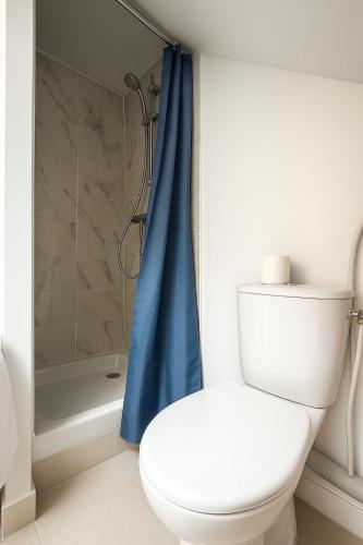 La salle de bains est pourvue de toilettes et d'un rideau de douche bleu. dans l'établissement Anh Dao 4 - Studio, centre ville, Université , Disneyland, à Champs-sur-Marne