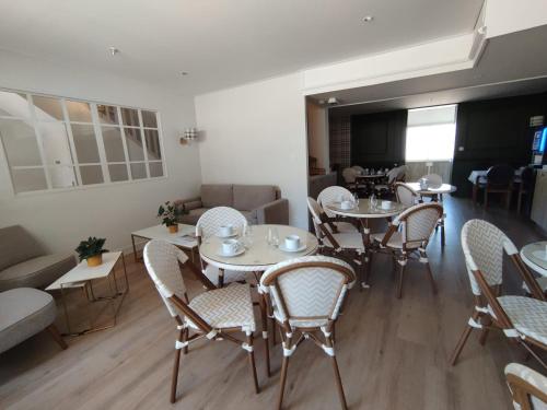 - une salle à manger avec des tables, des chaises et un canapé dans l'établissement Hotel Anne De Bretagne BLOIS, à Blois
