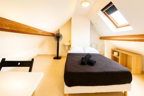 - une chambre mansardée avec un lit et une table dans l'établissement Anh Dao 4 - Studio, centre ville, Université , Disneyland, à Champs-sur-Marne