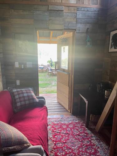a room with a couch and a door with a table at Gracies Grotto Cabin in Powell River