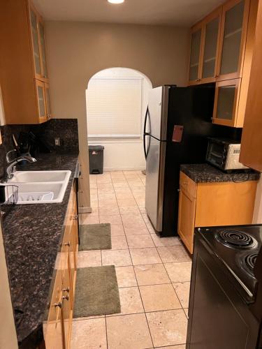 a kitchen with a refrigerator and a tile floor at Downtown Neighborhood Room 1 in Phoenix