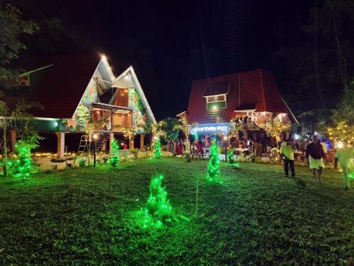 a group of people walking around a yard with green lights at River Valley Huts, Wayanad in Panamaram