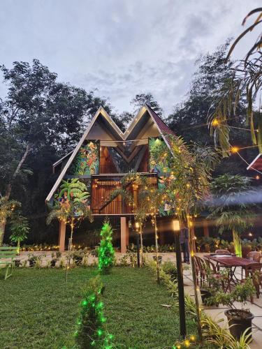 a house with a christmas tree in front of it at River Valley Huts, Wayanad in Panamaram