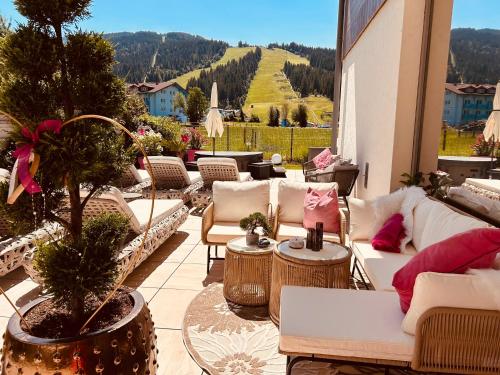 a patio with couches and tables and a view of a mountain at Enjoy The Alps in Flachau