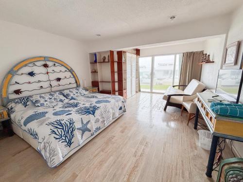 a bedroom with a bed with a blue and white bedspread at Brisas Shores Beach & OceanFront Apartments 1 or 2 bedrooms Cancun Hotel Zone in Cancún