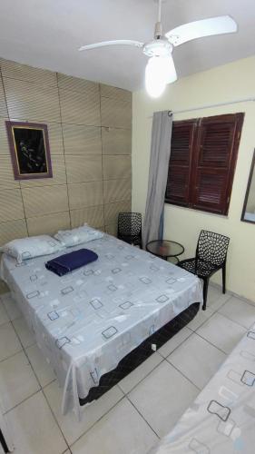 a bedroom with a bed and chairs in a room at Suites Solar dos Arcanjos Guaramiranga in Guaramiranga