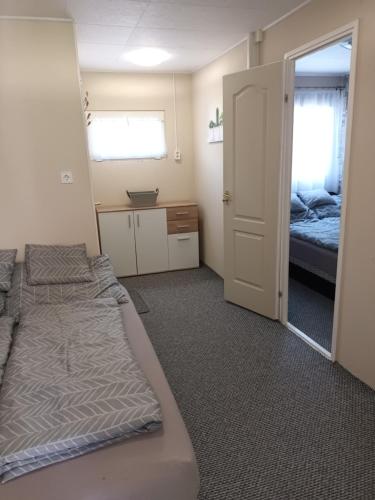 a room with two beds and a door with a mirror at Harmónia Vendégház Tiszakécske in Tiszakécske