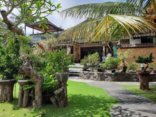 a garden with trees and plants in front of a house at Dana Bali Ricefield Villa in Candidasa