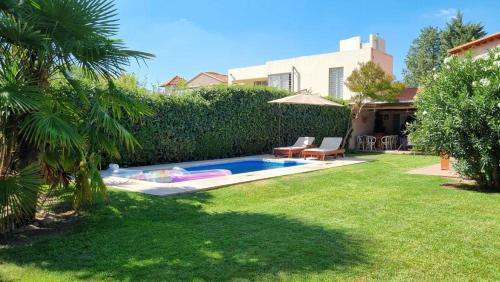 a backyard with a swimming pool in the grass at Chacras de Coria Relax in Ciudad Lujan de Cuyo