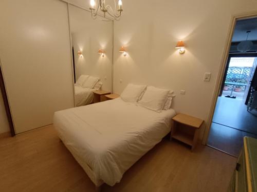 a bedroom with a white bed and a mirror at Le cœur de saint Florent in Saint-Florent