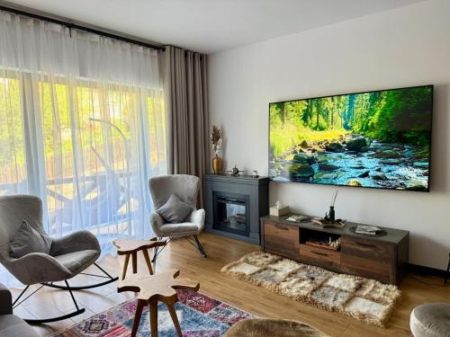 a living room with a flat screen tv on a wall at Vila Ferdinand Spa and Retreat in Sinaia