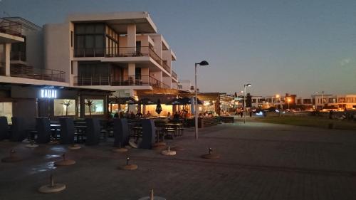 a parking lot with chairs and umbrellas in front of a building at Beachfront Penthouse with patio and free parking in Cape Town