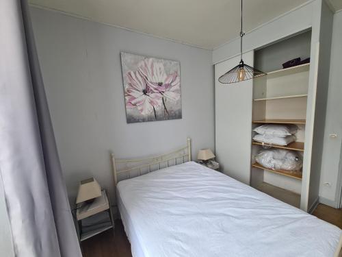 a bedroom with a bed and a painting on the wall at Appartement RDC centre ville in Bort-les-Orgues