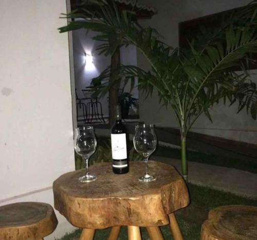a table with two glasses and a bottle of wine at Pousada pedra da baleia in São Miguel do Gostoso