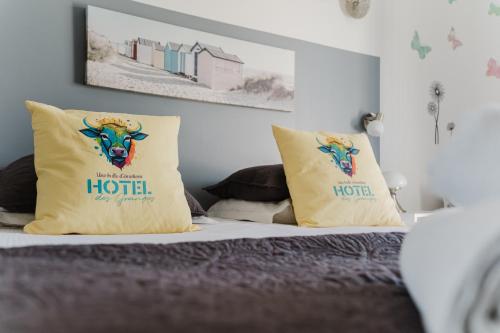 a bed with two pillows on top of it at Logis Hotel des Granges in Arles